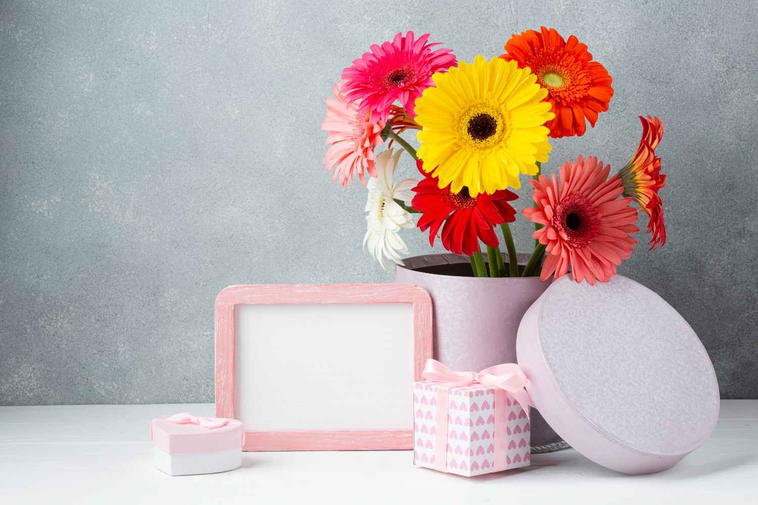 cute flower arrangement of gerbera daisies with gifts A beautiful flower arrangement of gerbera daisies of different colors